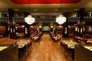 a dining room with tables and chairs and chandeliers at Pickalbatros White Beach Resort - Hurghada in Hurghada