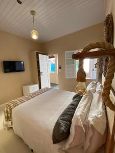 a bedroom with a large white bed in a room at Villamar Pousada in Morro de São Paulo