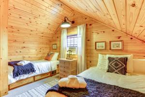a bedroom with two beds in a log cabin at 5 Mi to Beaver Lake Family Cabin with Game Room in Eureka Springs