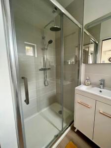 a shower with a glass door next to a sink at L'ATELIER de RUELLE in Ruelle-sur-Touvre