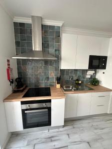 a kitchen with white cabinets and a stove top oven at Amadora Flat 3 in Amadora