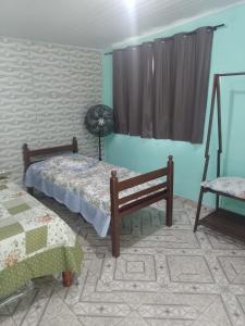 a room with two beds and a window at Apartamento em Chácara Aconchegante - Kitnet in Angra dos Reis