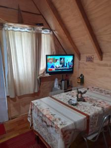 - un salon avec une table et une télévision dans l'établissement Type A cabana located in llifen, à llifen