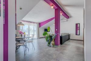 a dining room with purple columns and a table at Apartments Deepwater in Slatine