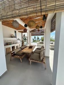 a dining room with a wooden table and chairs at Bahari View, Stylish Penthouse with breathtaking oceanviews and private rooftop pool in Kiwengwa