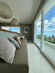 a large couch in a room with large windows at Bahari View, Stylish Penthouse with breathtaking oceanviews and private rooftop pool in Kiwengwa