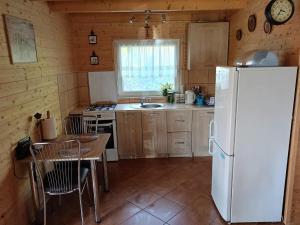 une cuisine avec un réfrigérateur blanc et une table dans l'établissement Holiday Home in Miedzyzdroje near Baltic Sea, à Międzyzdroje
