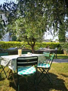 een tafel en stoelen onder een boom bij Ai Quattro Ulivi in Peschiera del Garda