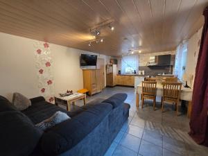 a living room with a blue couch and a kitchen at Haus Blume in Medebach +42 photos
