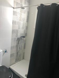 a bathroom with a shower with a black shower curtain at Silent coast apartment in Las Galletas