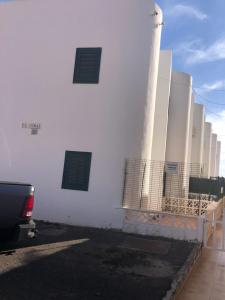 a white building with two windows on the side of it at Silent coast apartment in Las Galletas