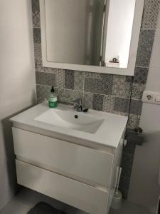 a bathroom with a white sink and a mirror at Silent coast apartment in Las Galletas
