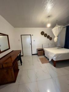a bedroom with a bed and a desk and a piano at Kasuba Apartments in Livingstone
