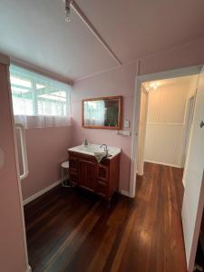 un baño con lavabo y espejo en Beach side, air conditioned, 3 bedroom cottage, en Urangan 14 fotos más