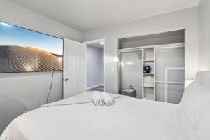 a bedroom with a white bed with two shoes on it at Entire Private 2-Bedroom Home w Gated Yard, Driveway Parking, Available Now in Spring Valley +43 photos