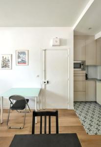 a kitchen with a table and a chair and a refrigerator at Studio de charme à Montrouge - 20 m² - Internet inclus in Montrouge