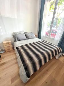 a bed in a room with a large window at Studio de charme à Montrouge - 20 m² - Internet inclus in Montrouge