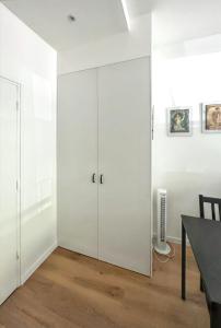 a white room with a large white cabinet at Studio de charme à Montrouge - 20 m² - Internet inclus in Montrouge +4 photos