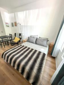 a bedroom with a bed with a black and white blanket at Studio de charme à Montrouge - 20 m² - Internet inclus in Montrouge