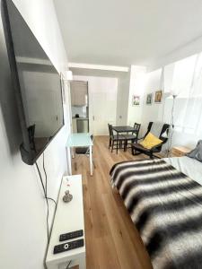 a room with a bed and a tv and a table at Studio de charme à Montrouge - 20 m² - Internet inclus in Montrouge +4 photos