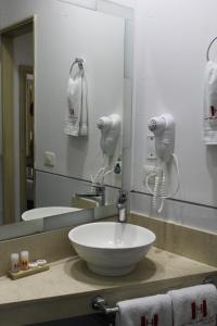 a bathroom with a bowl sink and a mirror at Hotel Merlott Lleras in Medellín +90 photos