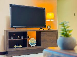 a flat screen tv on top of a wooden entertainment center at Apartamento completo Ideal para descansar en familia en San Salvador in San Salvador