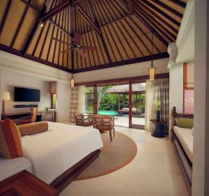 a bedroom with a bed and a living room at Hilton Bali Resort in Nusa Dua
