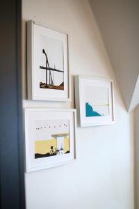 trois photographies encadrées sur un mur dans une pièce dans l'établissement Sound of the Sea - Penthouse in Portrush, à Portrush 34 autres photos