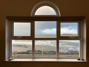 une fenêtre avec vue sur l'océan dans l'établissement Sound of the Sea - Penthouse in Portrush, à Portrush