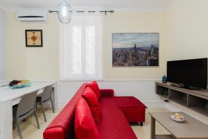 a living room with a red couch and a table at Casetta Fardella 95 in Trapani +62 photos