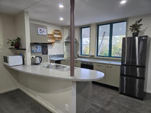a kitchen with a large counter with a refrigerator at Parkhill Apartment in CBD in Whangarei