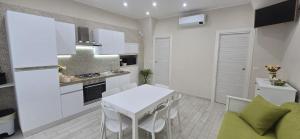 a kitchen with a white table and a white table and chairs at Gesuiti Home di Agata e Aurora in Catania