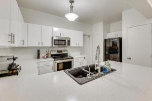 a kitchen with white cabinets and a sink in it at 3 Mi to Dtwn Mesa Townhome with Patio in Mesa