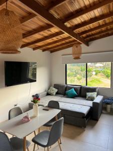 a living room with a couch and a table at Cabaña rodeada de frutales - Granja la miel in Corrales