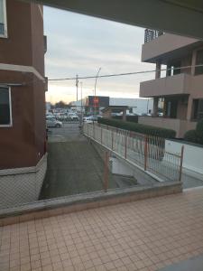 a fence in front of a building with a parking lot at Casa enna in Piacenza