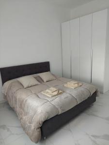 a bed in a white room with two towels on it at Casa enna in Piacenza