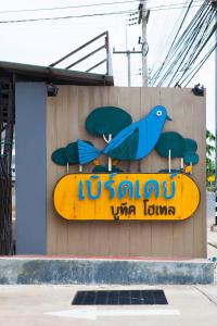 a sign on the side of a building with a surfboard at Bird Day Boutique Hotel in Mukdahan