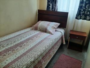 ein kleines Schlafzimmer mit einem Bett und einem Tisch in der Unterkunft Departamento portal del mar in La Serena