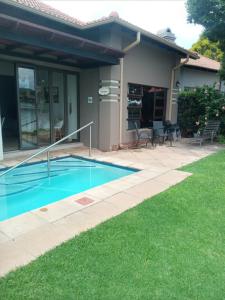 a swimming pool in the backyard of a house at Pecanwood Estate Cosy home 3 bedrooms with pool in Hartbeespoort