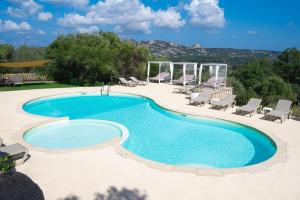 a swimming pool with chaise lounge chairs and a pool at Moma Hotel Cannigione in Cannigione