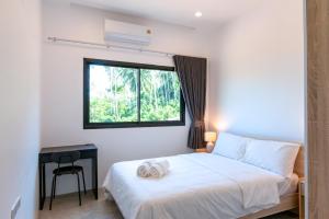 a bedroom with a white bed and a window at Scenic Lamai Getaway in Amphoe Koh Samui