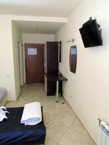 Zimmer mit einem Bett, einem Schreibtisch und einem TV in der Unterkunft Afrodita Hotel in Sinemorets