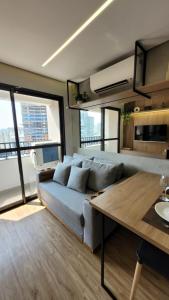 ein Wohnzimmer mit Sofa und Tisch in der Unterkunft Apto novo e moderno - 5 min do Allianz parque in São Paulo