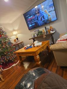 a living room with a christmas tree and a flat screen tv at Country living in Pine Mountain