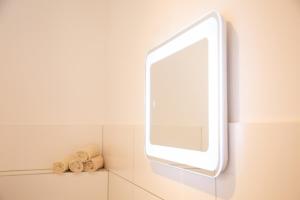 a bathroom with a mirror and three rolled towels at Meisterhaus Appartment 5 in Glauchau
