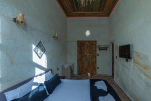 a bedroom with a bed and a wooden door at Keyf i ala capadocia in Ürgüp