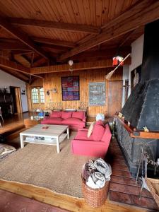 ein Wohnzimmer mit roten Möbeln und einem großen Kamin in der Unterkunft Casa de playa con vista al mar in Santo Domingo