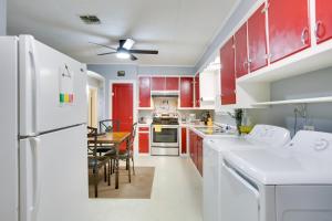 una cocina con electrodomésticos blancos y armarios rojos en Walk to 1st Street Family Home in Thibodaux!, en Thibodaux