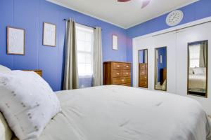 1 dormitorio con paredes azules y 1 cama blanca en Walk to 1st Street Family Home in Thibodaux!, en Thibodaux