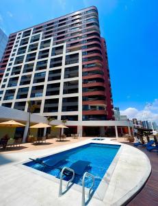 a large building with a swimming pool in front of a building at Flat Iate in Fortaleza